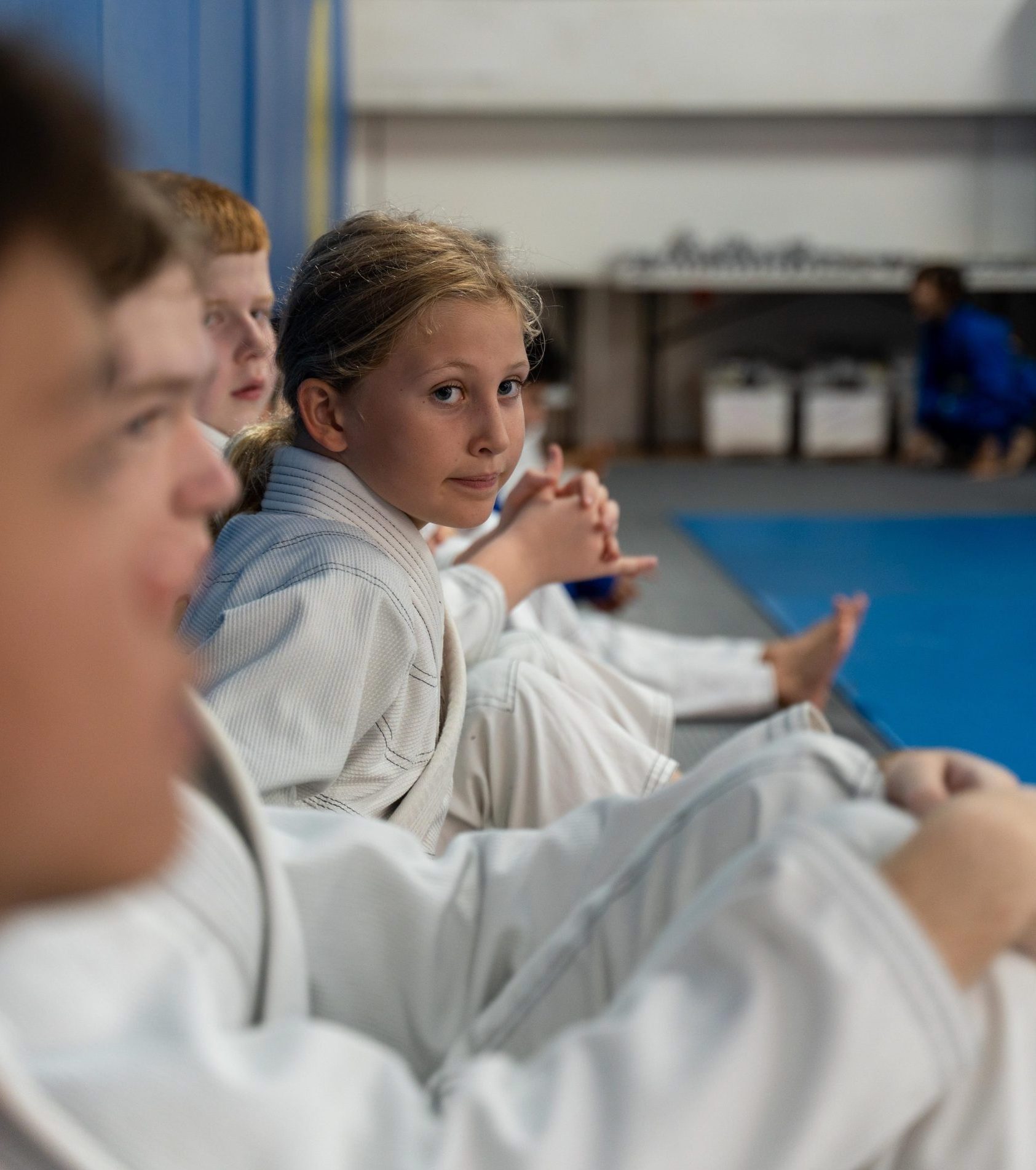 Girl between boys training BJJ